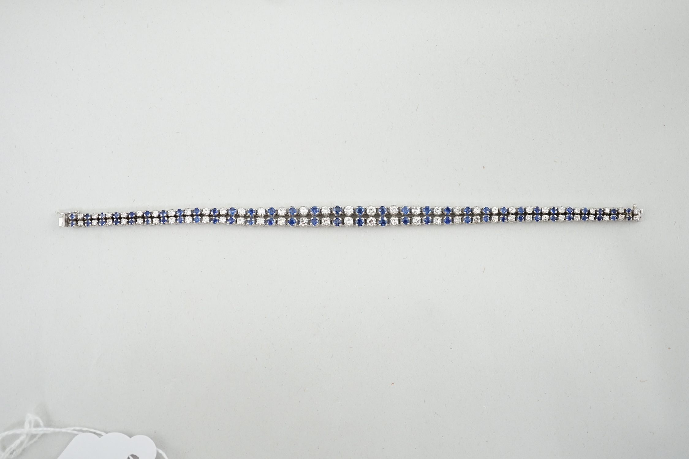 A 1960's 14ct white gold, sapphire and diamond two row line bracelet